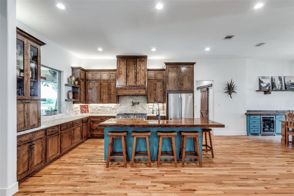 626 Lone Tree Road Nevada, TX 75173 - Photo 5 of 40 a kitchen with stainless steel appliances kitchen island granite countertop a table and chairs in it