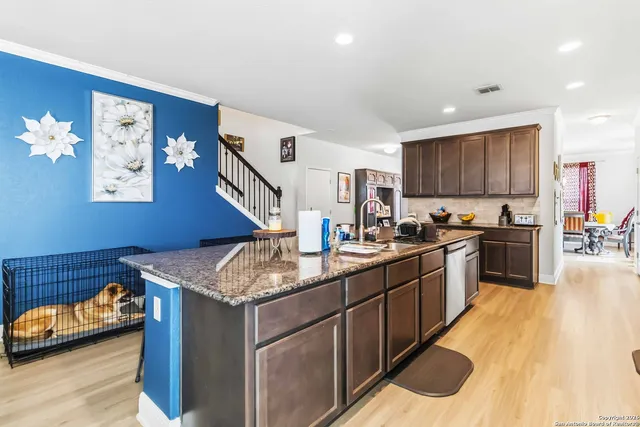 a kitchen with granite countertop a sink stove and wooden cabinets