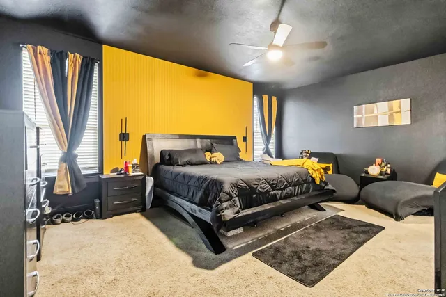 a bedroom with a bed couch and a large window