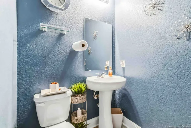 a bathroom with a sink toilet and a mirror