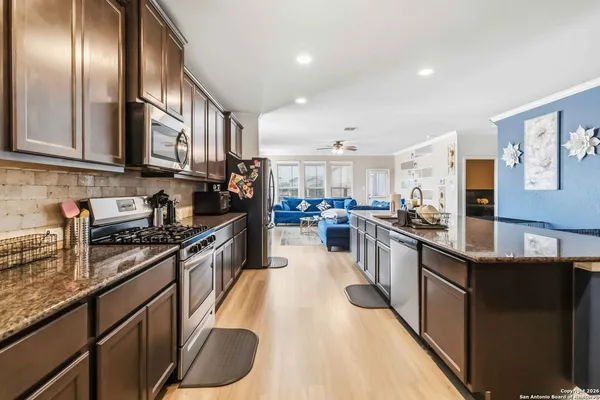 a large kitchen with stainless steel appliances granite countertop a stove refrigerator and a sink