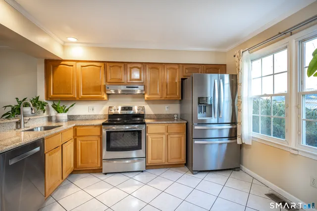 a kitchen with stainless steel appliances a refrigerator sink and microwave