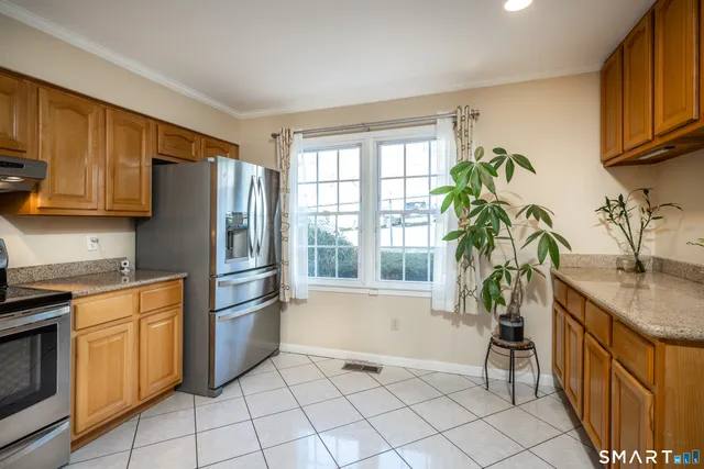a kitchen with stainless steel appliances granite countertop a refrigerator and a sink