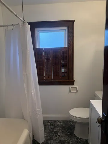 a bathroom with a toilet and a shower curtain