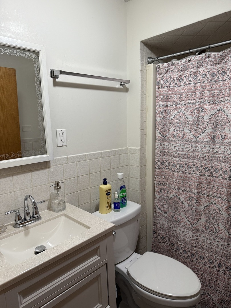 3035 Peoria Street Steger, IL 60475 - Photo 18 of 19 a bathroom with a sink a toilet and shower curtain