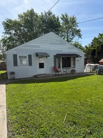 a front view of house with yard and outdoor seating