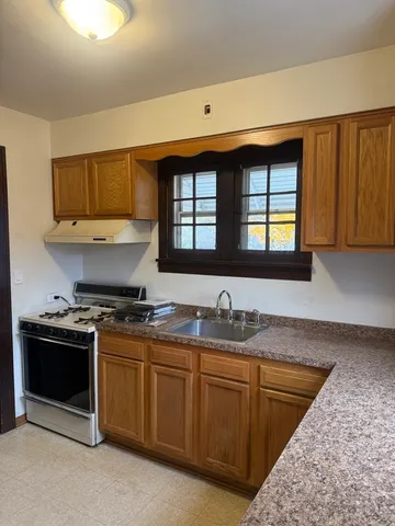 a kitchen with stainless steel appliances granite countertop a sink stove and cabinets