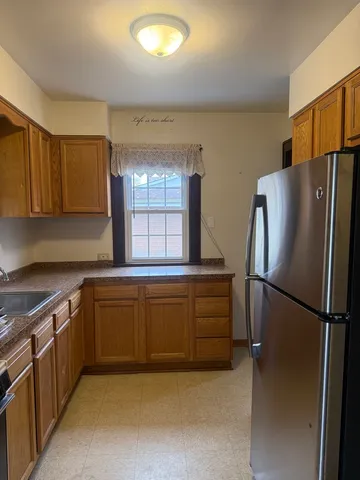 a kitchen with stainless steel appliances granite countertop a refrigerator a sink and a stove