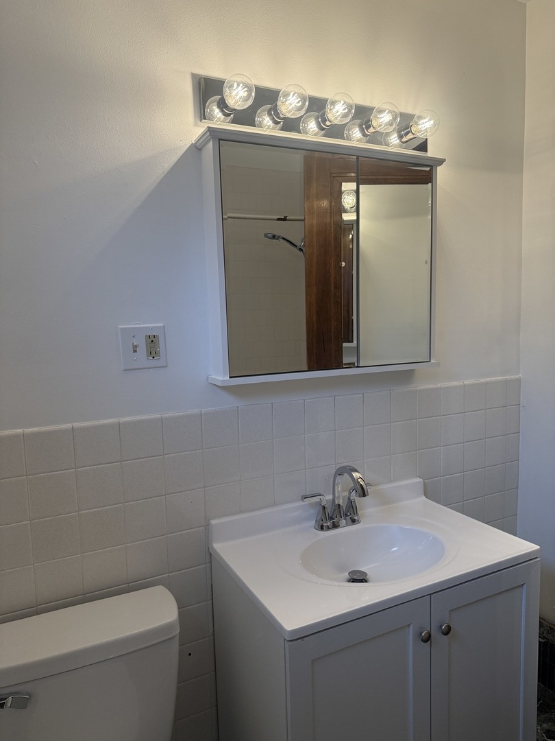 3035 Peoria Street Steger, IL 60475 - Photo 10 of 19 a bathroom with a toilet sink and mirror