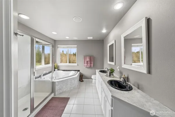 a spacious bathroom with a sink a mirror a bathtub and next to a window