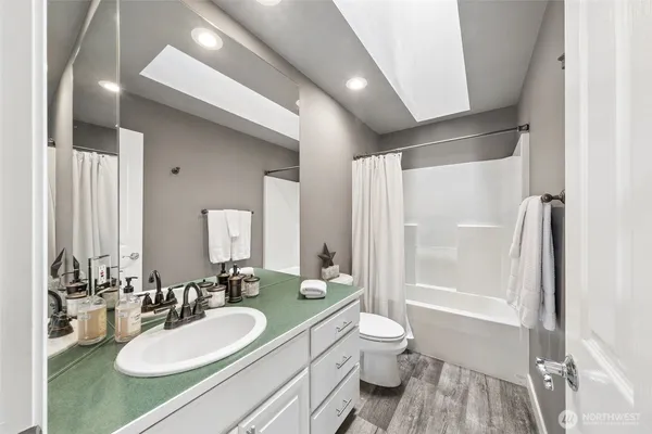 a bathroom with a sink a toilet and shower