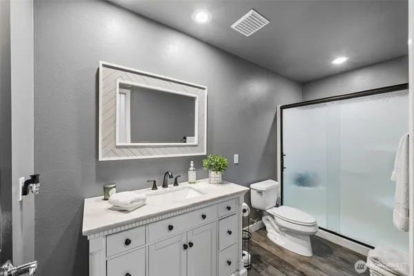 a bathroom with a granite countertop sink toilet and shower