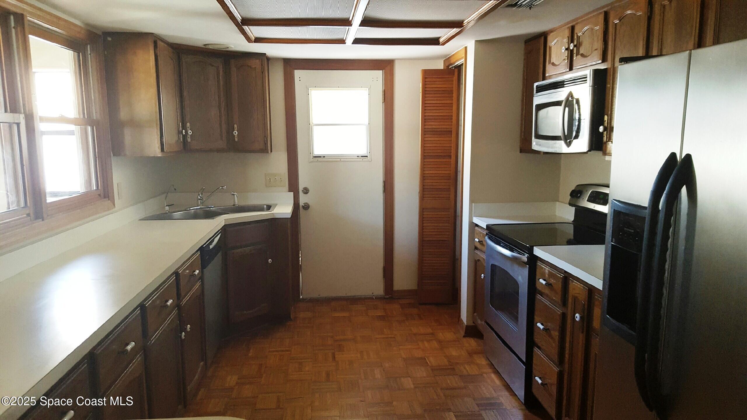 120 Cortez Street Melbourne Beach, FL 32951 - Photo 4 of 7 a kitchen with stainless steel appliances granite countertop a sink stove and refrigerator