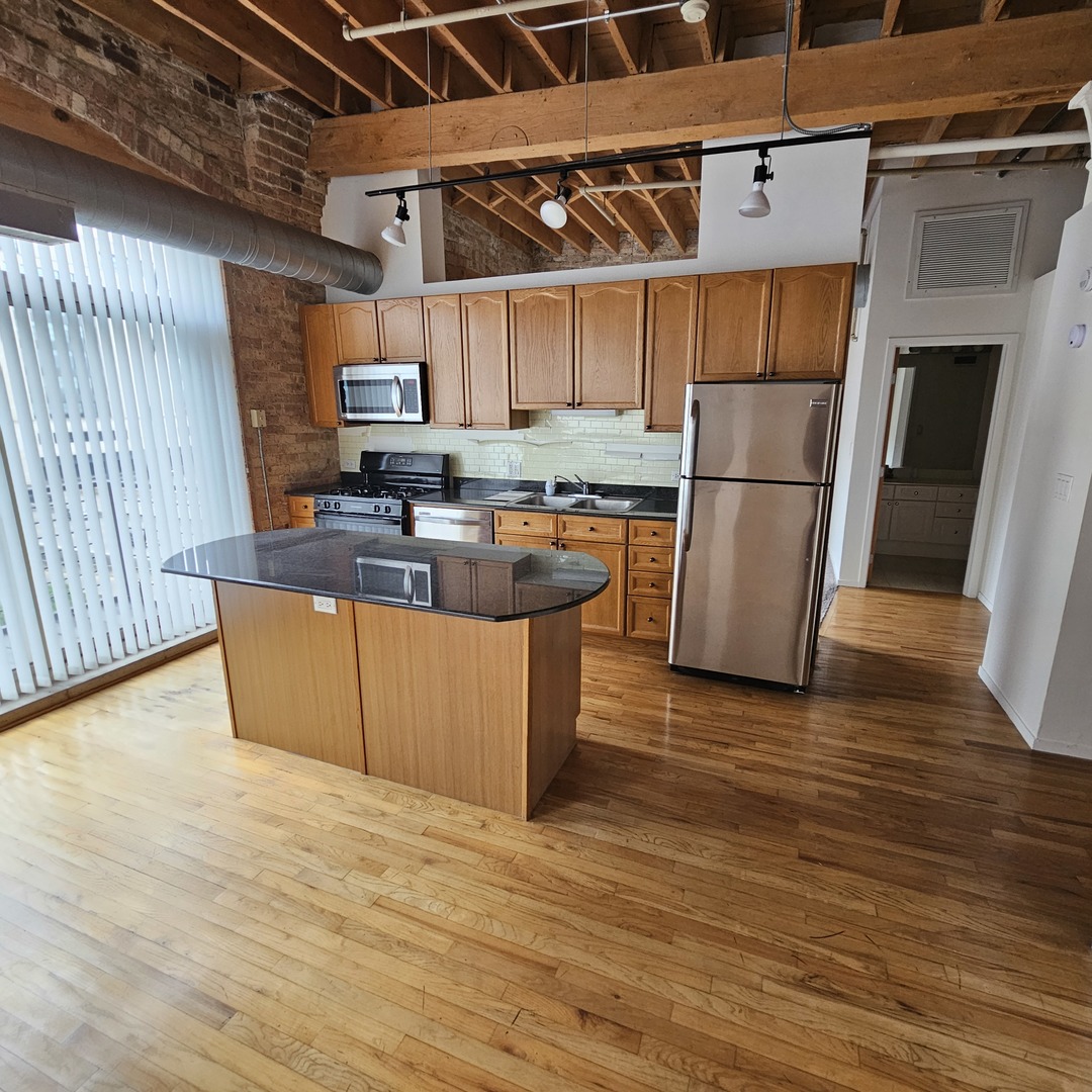 420 South Clinton Street, Unit 607 Chicago, IL 60607 - Photo 3 of 11 a view of a kitchen with wooden floor