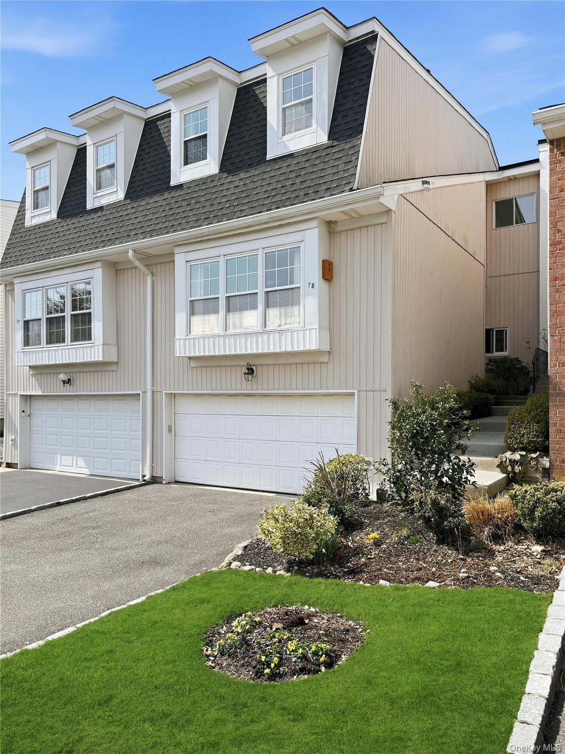 a front view of a house with a garden and plants