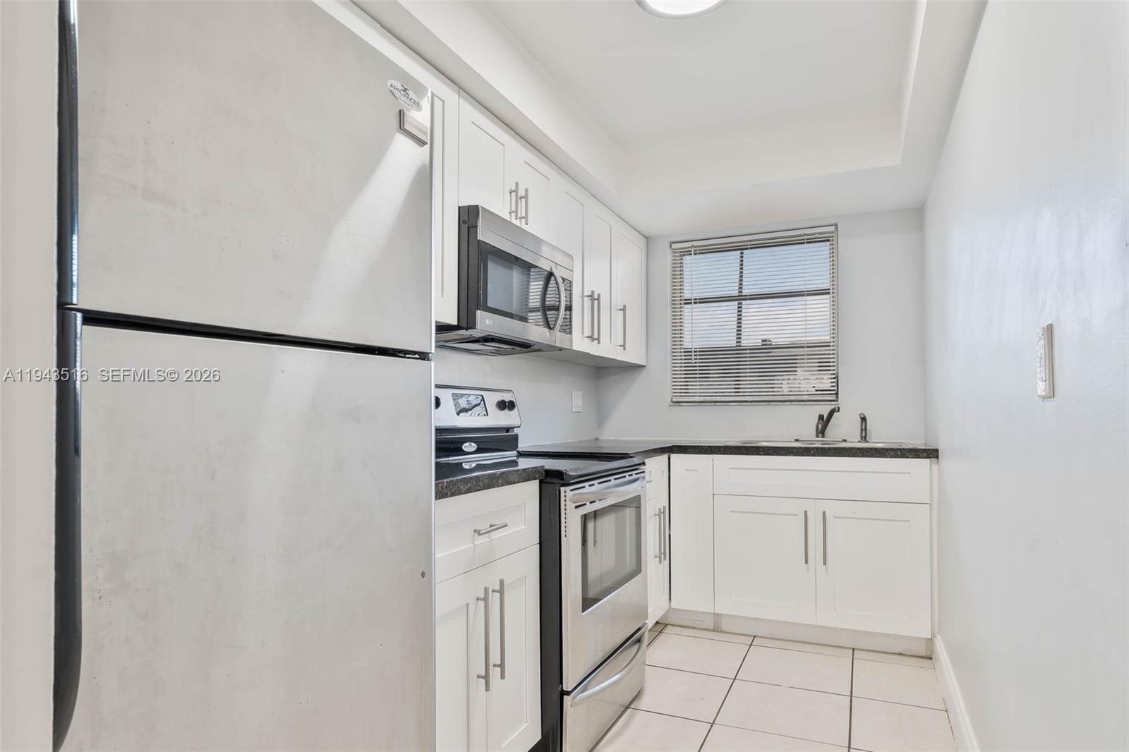 7324 Southwest 82nd Street, Unit B108 Miami, FL 33143 - Photo 7 of 17 a kitchen with stainless steel appliances a refrigerator sink and cabinets