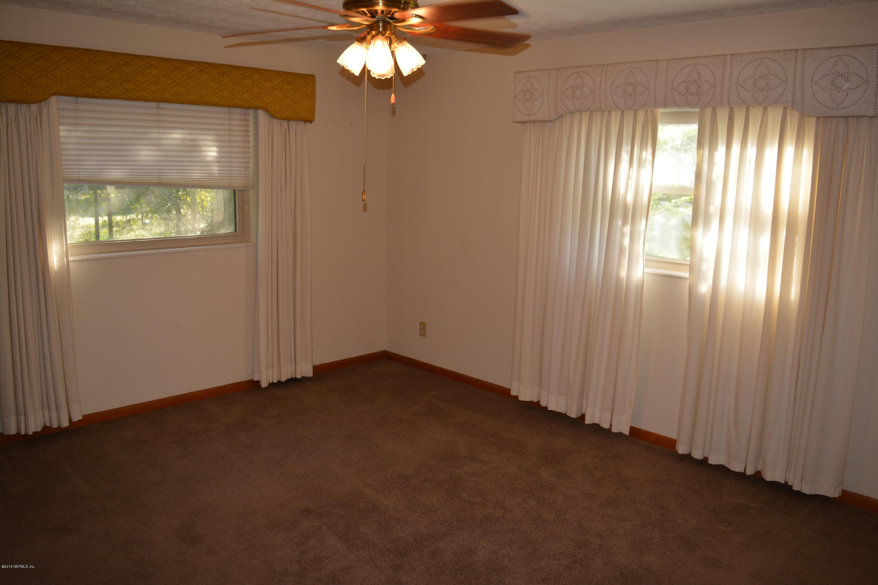 4061 Appaloosa Road Middleburg, FL 32068 - Photo 21 of 43 an empty room with windows and chandelier fan