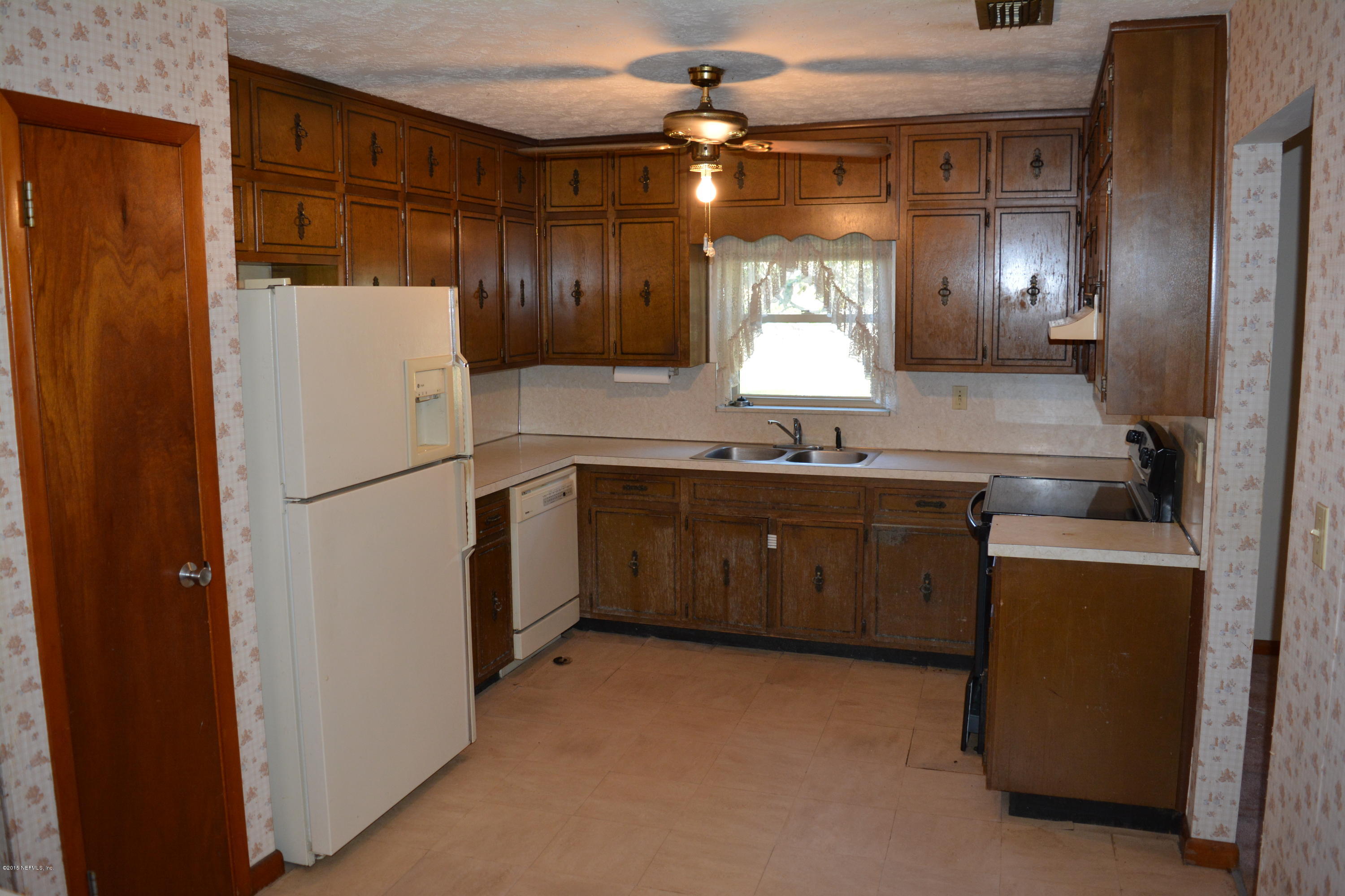 4061 Appaloosa Road Middleburg, FL 32068 - Photo 7 of 43 a kitchen with a sink refrigerator and cabinets