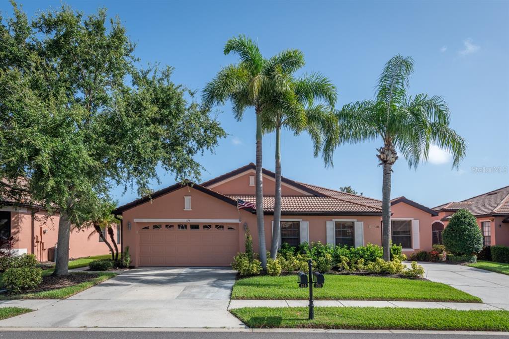 124 Shell Falls Drive Apollo Beach, FL 33572 - Photo 1 of 1 a view of a white house with a yard and palm trees