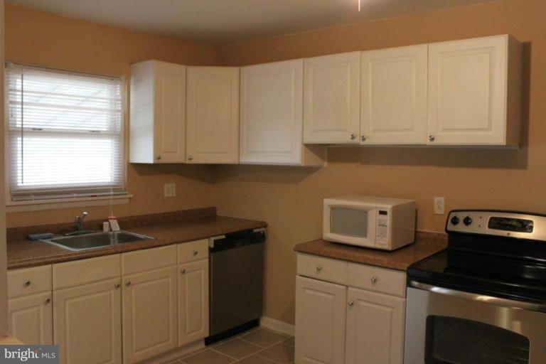 9415 Windpine Road, Unit 9415 Middle River, MD 21220 - Photo 2 of 11 a kitchen with white cabinets sink and dishwasher