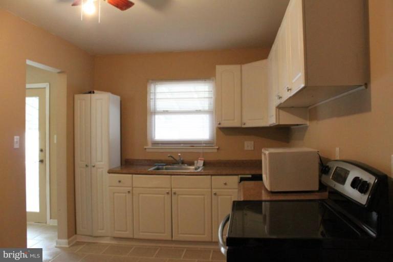 9415 Windpine Road, Unit 9415 Middle River, MD 21220 - Photo 8 of 11 a kitchen with a sink cabinets and a window