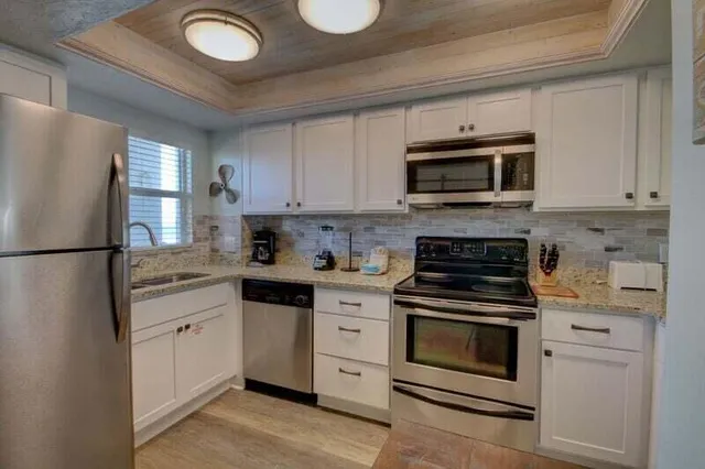 a kitchen with white cabinets stainless steel appliances and sink