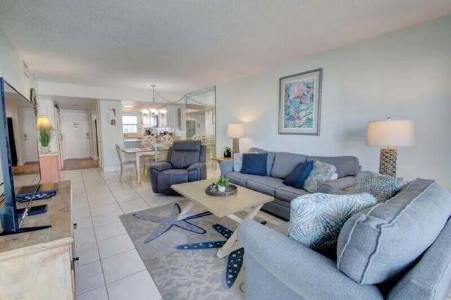 a living room with furniture a table and a flat screen tv