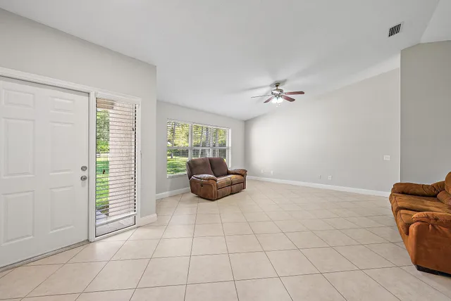a living room with furniture and a ceiling fan