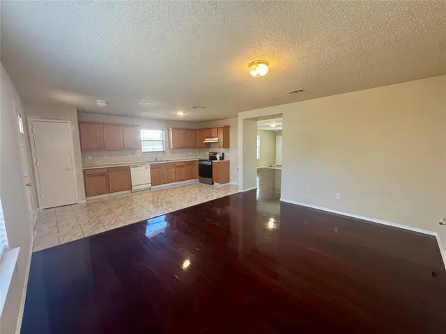 a view of an empty room and wooden floor and a window