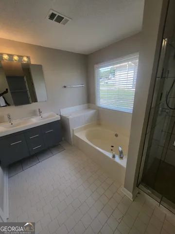 a bathroom with a tub sink and mirror