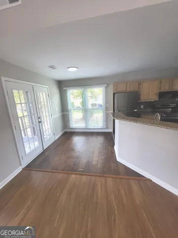 an empty room with wooden floor and windows