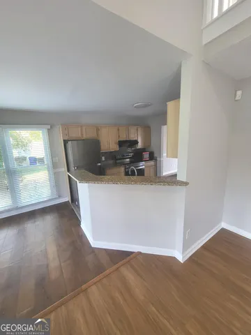 a kitchen with stainless steel appliances a sink a stove a microwave a sink a refrigerator and window