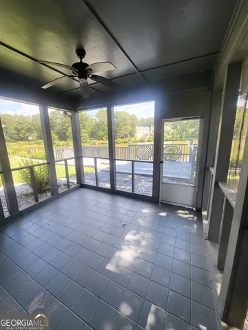 a view of an empty room with a fireplace and windows