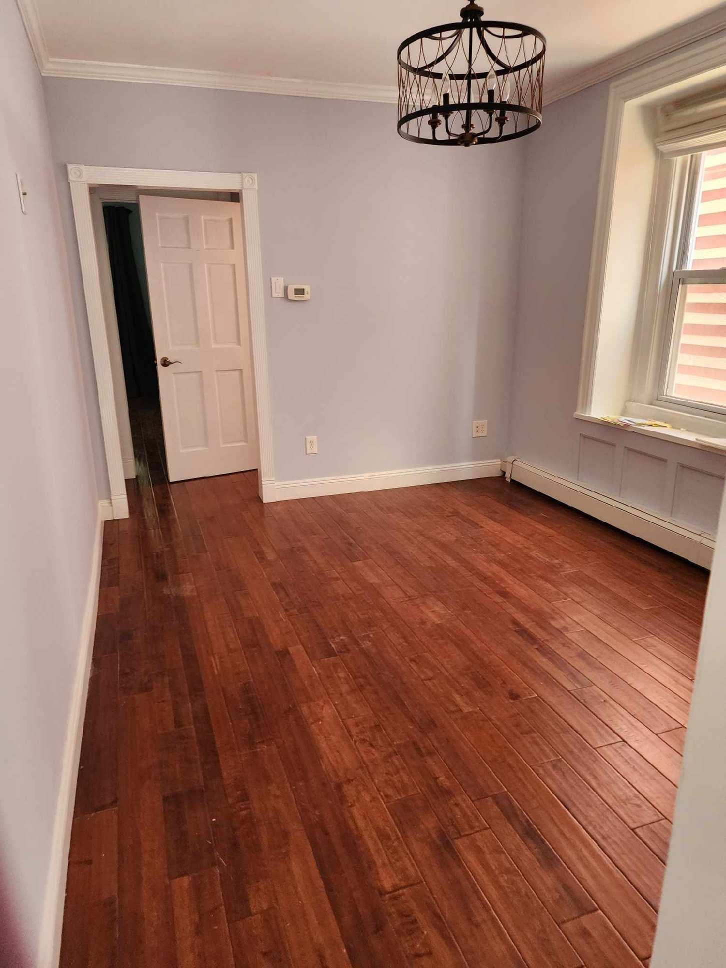 148 Nesbit Street, Unit 1 Weehawken, NJ 07086 - Photo 4 of 13 a view of an empty room with window and wooden floor