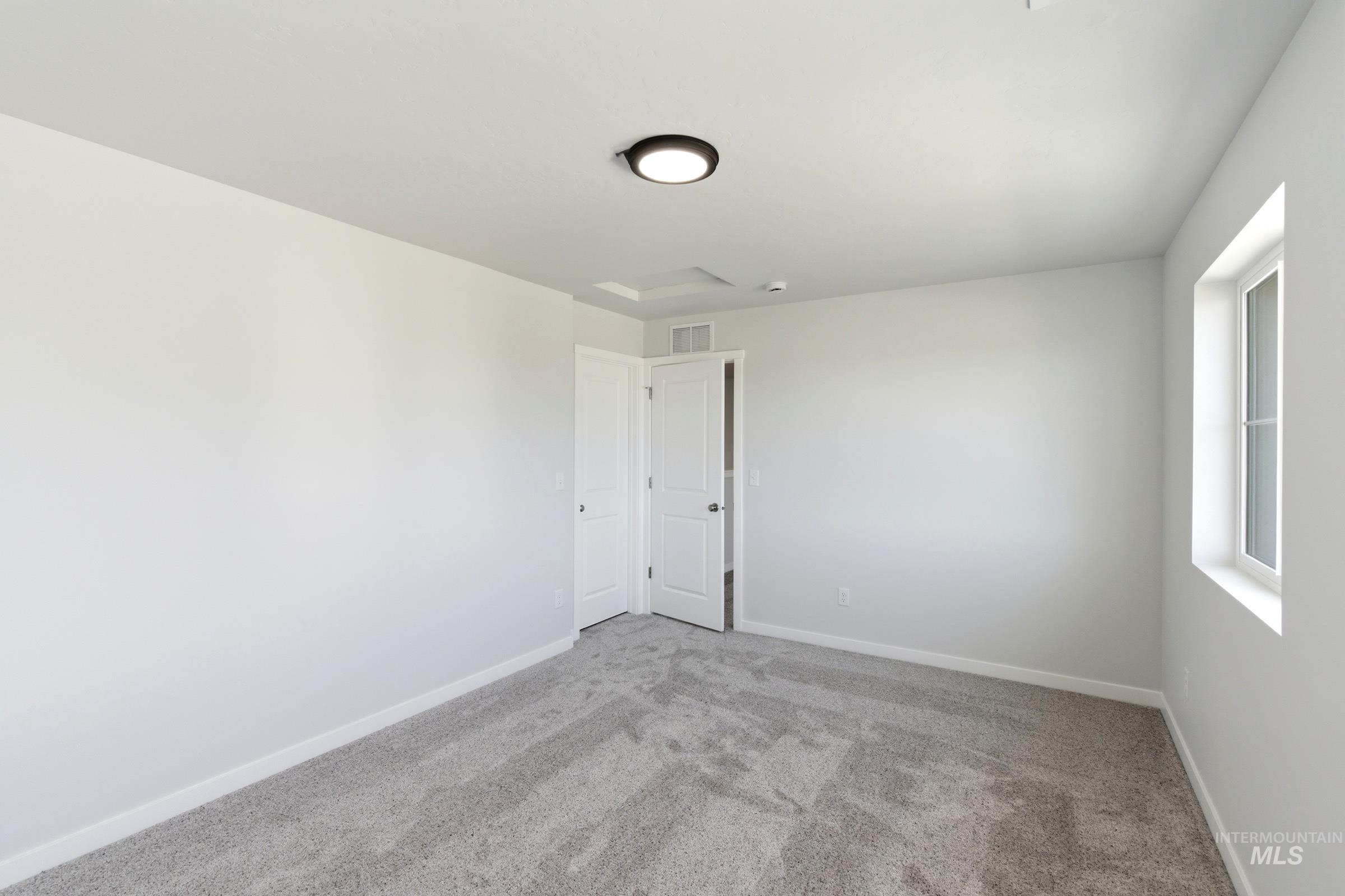 13677 Redway Court Caldwell, ID 83607 - Photo 21 of 35 Room featuring light gray carpeting, neutral wall paint, and a modern flush-mount ceiling light