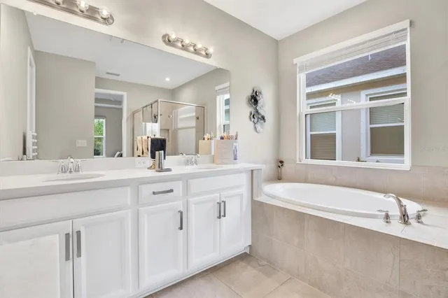 a bathroom with a granite countertop sink mirror and a bathtub