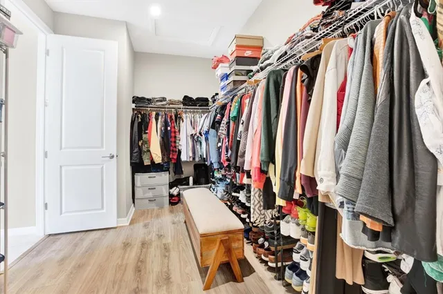 a view of walk in closet with clothes and shoes