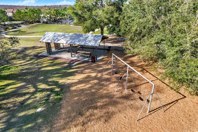 an aerial view of residential houses with outdoor space and trees