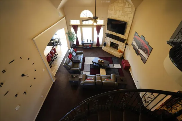 a living room with furniture a flat screen tv and a chandelier