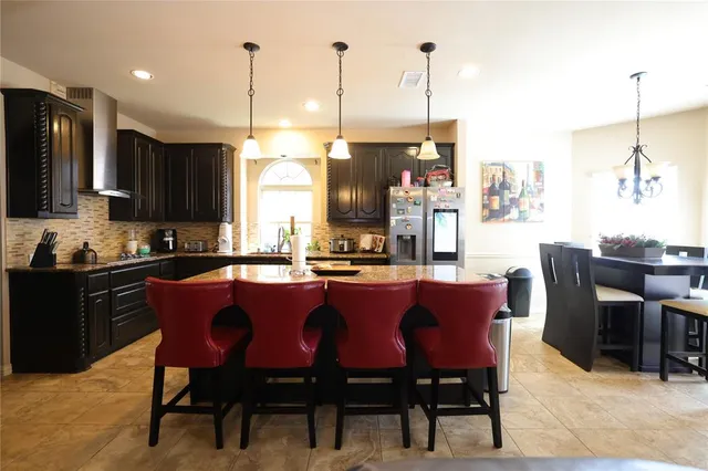 a kitchen with stainless steel appliances granite countertop sink stove top oven and cabinets