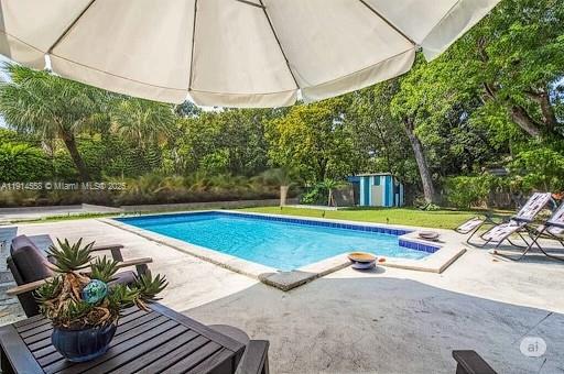 a view of a swimming pool with a patio and a yard