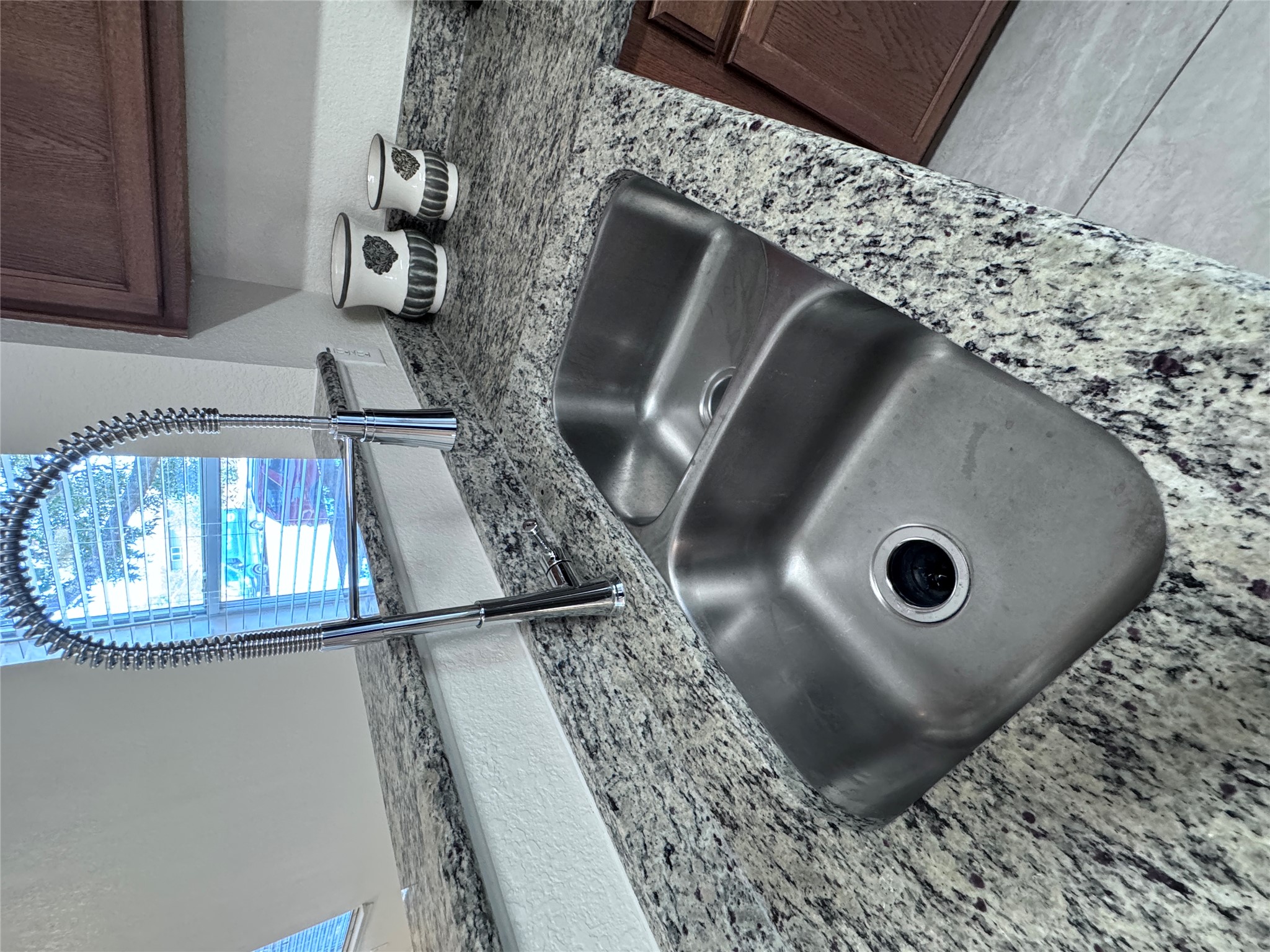 3411 Wickham Lane Austin, TX 78725 - Photo 14 of 20 Kitchen view of light granite countertops, dark wood finish cabinets.