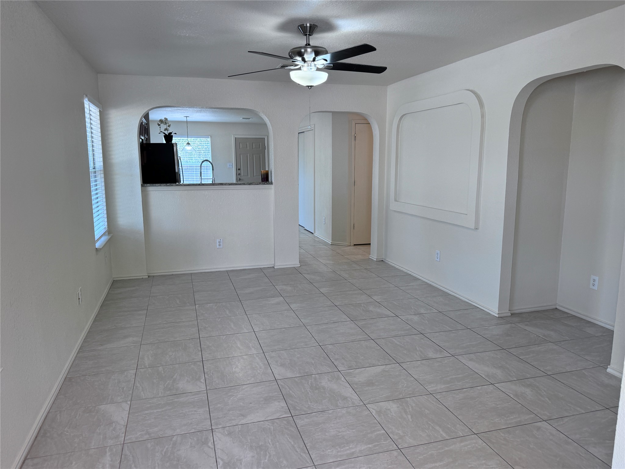 3411 Wickham Lane Austin, TX 78725 - Photo 2 of 20 Family room featuring ceiling fan, arched walkways, and light ceramic tile patterned floors