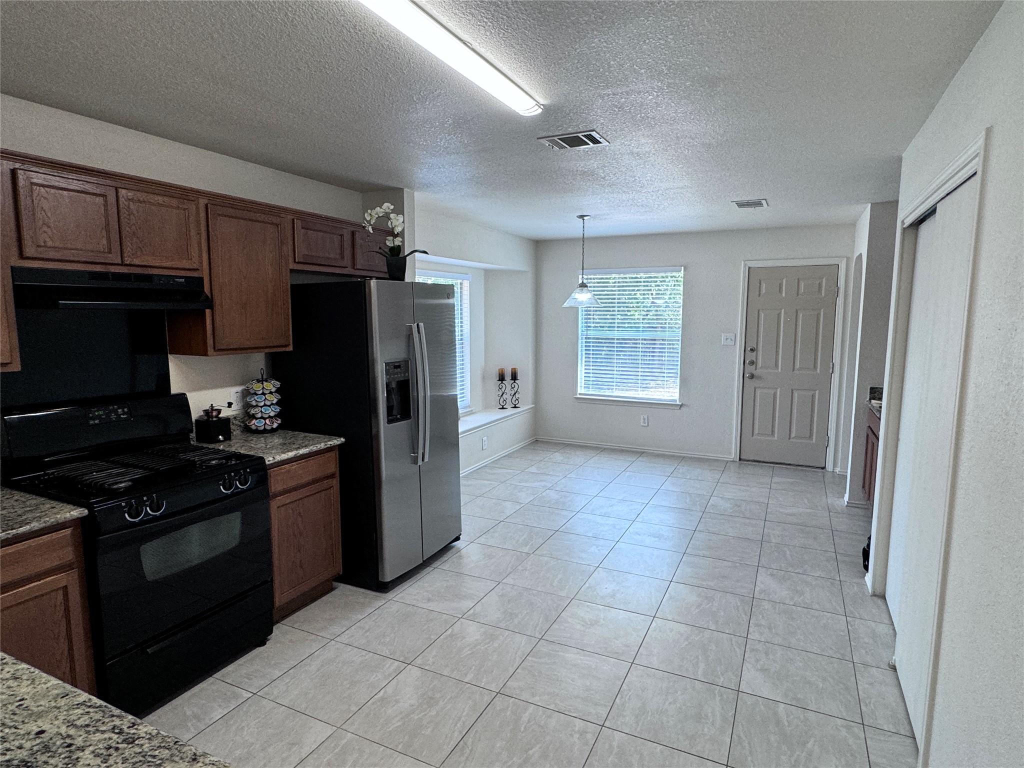 3411 Wickham Lane Austin, TX 78725 - Photo 5 of 20 Kitchen with stainless steel fridge with ice and water dispenser, breakfast and dining.