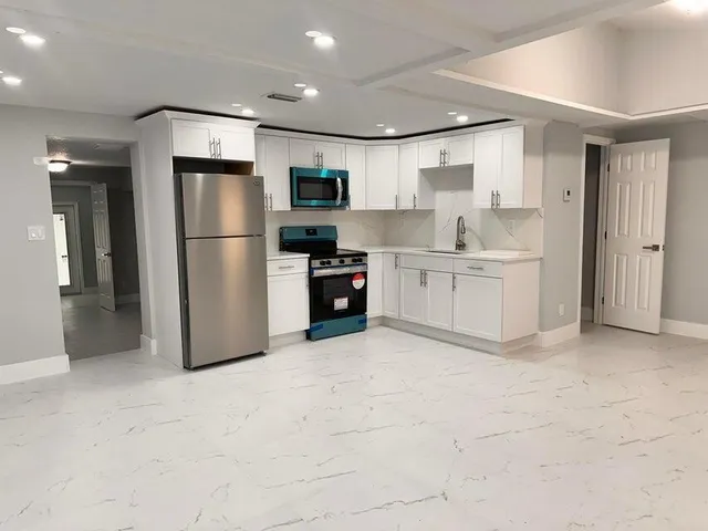 a large kitchen with cabinets and stainless steel appliances