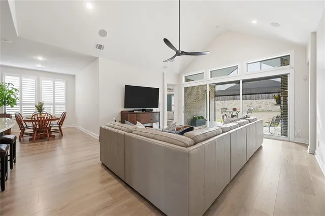 a living room with furniture a flat screen tv and a large window