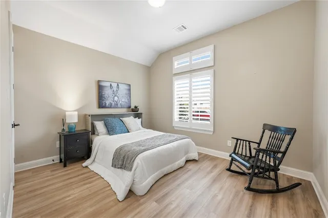 a bedroom with a bed and a wooden floor