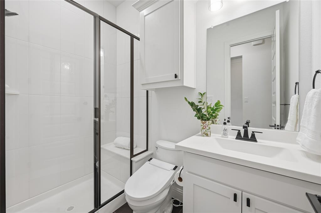4409 Lk Vw Road Oak Point, TX 75068 - Photo 18 of 40 a bathroom with a sink a toilet a mirror and shower