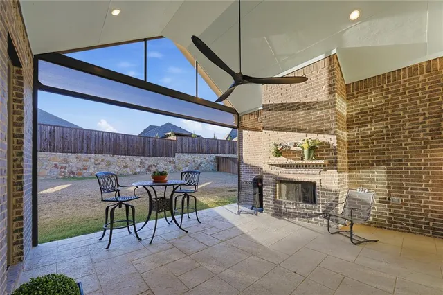 a patio with a fireplace and chairs