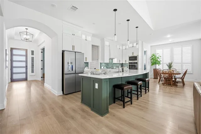a room with stainless steel appliances kitchen island granite countertop furniture and a refrigerator